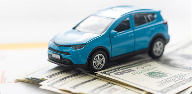 Blue toy car sitting on $100 bills