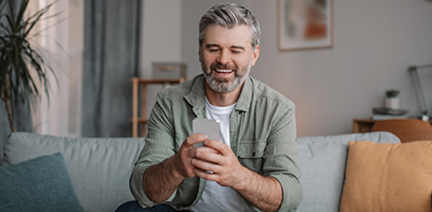Man smiling and looking at phone